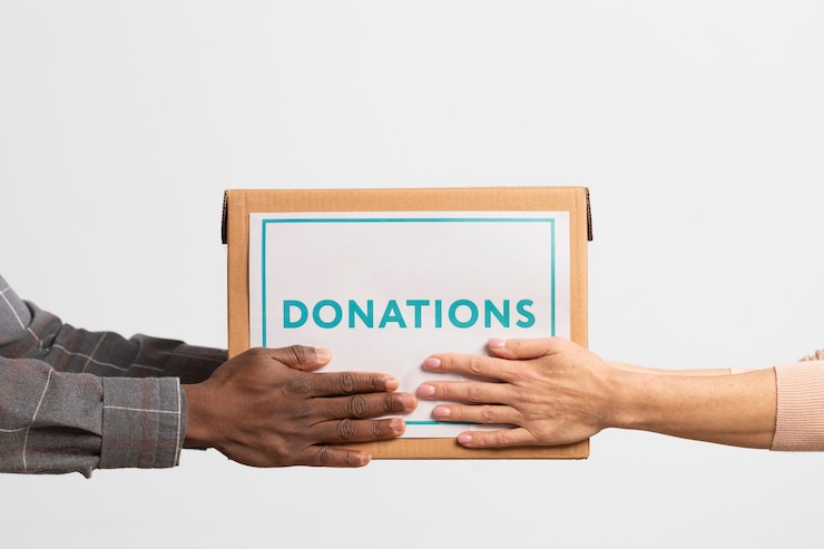 volunteer-giving-box-with-donations-another-volunteer_23-2149230558